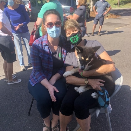 Team member with mask on and puppies