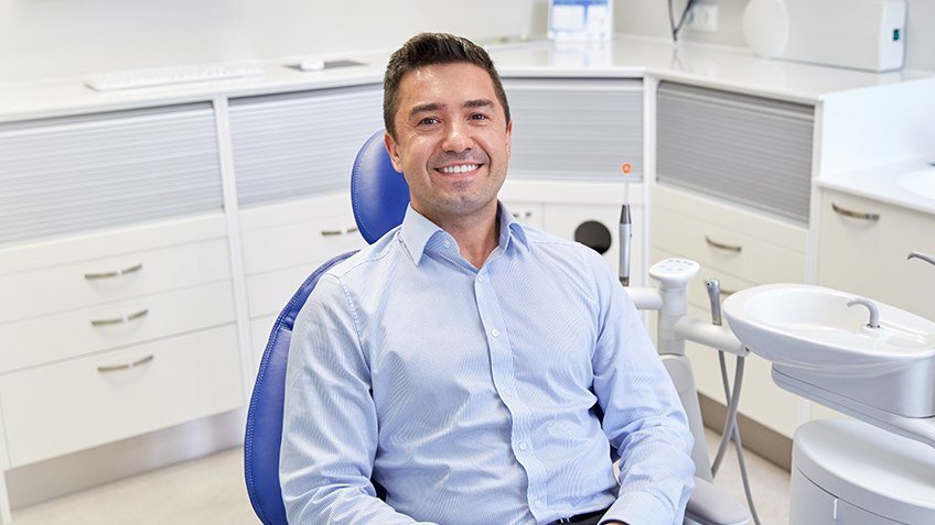 man smiling at camera in chair