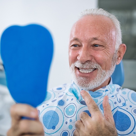 man checking smile in blue mirror