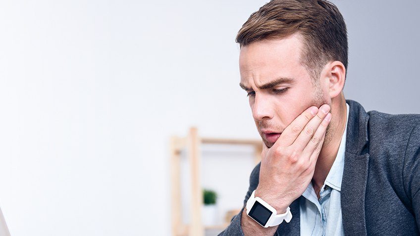 man holding jaw in pain