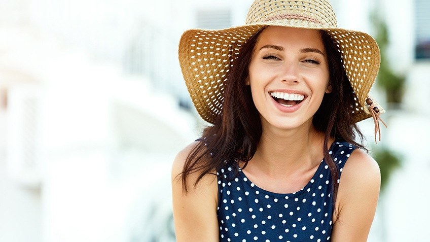 woman laughing with sunhat on