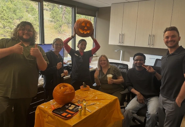 Team enjoying a community pumpkin carving event