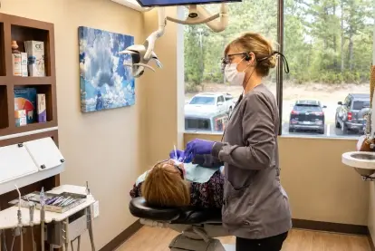 Dentist performing preventive dental treatment on patient in modern dental office in Evergreen, Colorado.