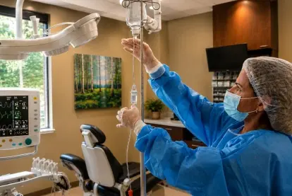 Dentist administering IV sedation to patient during dental procedure in Evergreen office.