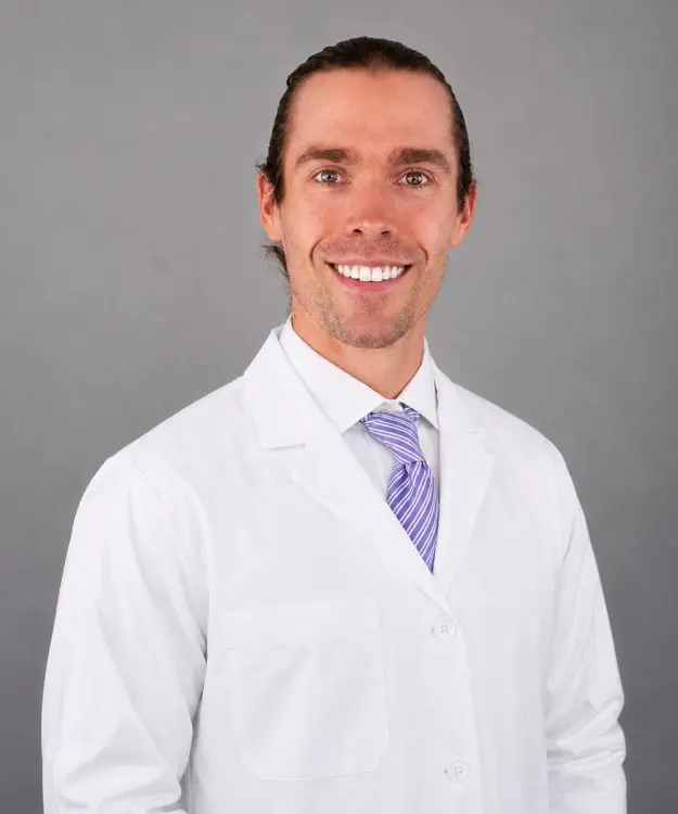 Dr. Joseph Burns, dentist at Evergreen dental practice, in white coat and purple striped tie.